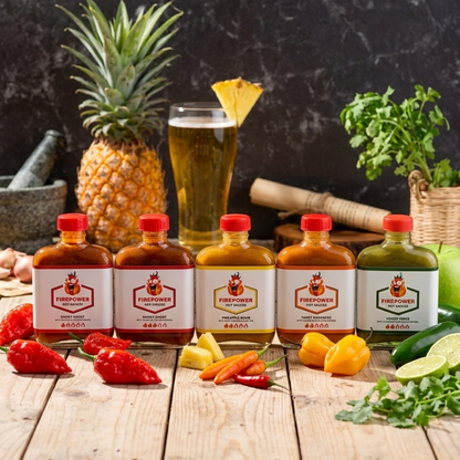 Five 85ml bottles of Firepower craft hot sauce — Smoky Ghost Levels 1 and 3, Tangy Habanero, Venom Verde and Pineapple Bomb — a hot sauce gift set made in Bangkok.
